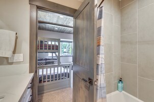 Un baño con bañera, cortina de ducha y un perchero.