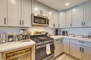 Una cocina moderna con electrodomésticos de acero inoxidable, incluyendo estufa, horno y microondas, y armarios de tonos claros.