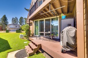 Un patio techado al aire libre con mesa y sillas, una parrilla y una puerta corrediza de vidrio que da a una terraza.