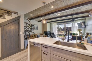 Una cocina moderna con lavavajillas integrado, una isla grande con pileta y un comedor con mesa y sillas.