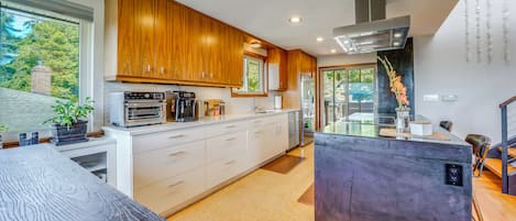 Una cocina moderna con armarios de madera, electrodomésticos de acero inoxidable y una isla central.