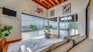A modern room with a large window, a sofa, and a chair. - 1/2 Mi to Alki Beach + Puget Sound Views! (Seattle)