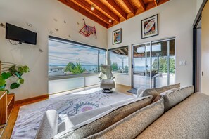 A modern room with a large window, a sofa, and a chair. - 1/2 Mi to Alki Beach + Puget Sound Views! (Seattle)