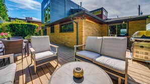 A modern outdoor patio with wicker furniture, a round table, and a decorative lantern. - 1/2 Mi to Alki Beach + Puget Sound Views! (Seattle)