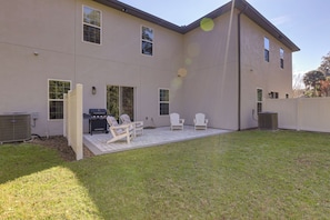 A two-story house with a patio area featuring outdoor furniture and a grill. - Gateway to Wec! Twin Ocala Townhomes (Ocala)