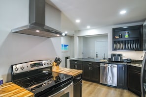 A modern kitchen with stainless steel appliances, wooden countertops, and a built-in oven. - Walk to Beach! Prime Okaloosa Island Townhome (Fort Walton Beach)