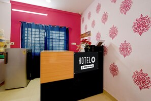 Eine Hotelrezeption mit einem Schild, auf dem 'HOTELO' und 'OYO-Serviced' steht.