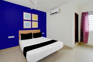 A bedroom with a bed, a ceiling fan, an air conditioner, and a window with curtains. - Hotel O Netaji Park Hyderabad (Hyderabad)