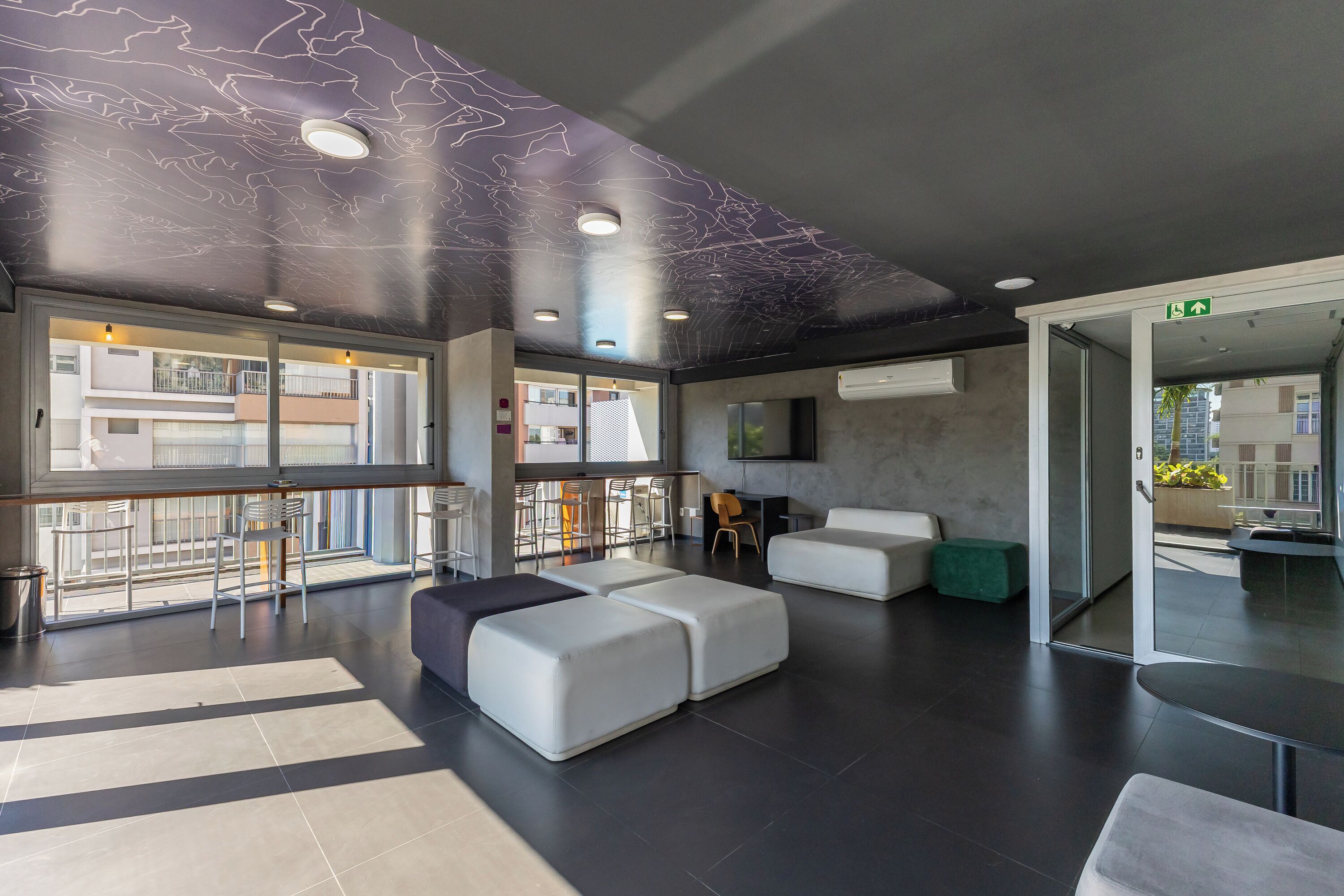 Een moderne lobby met een zithoek, een bar en een groot raam met uitzicht.