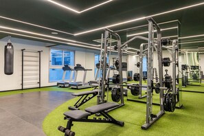 A gym with exercise equipment, treadmills, and weightlifting stations. - Moema | Studio + 9 min Airport and Parking (São Paulo)