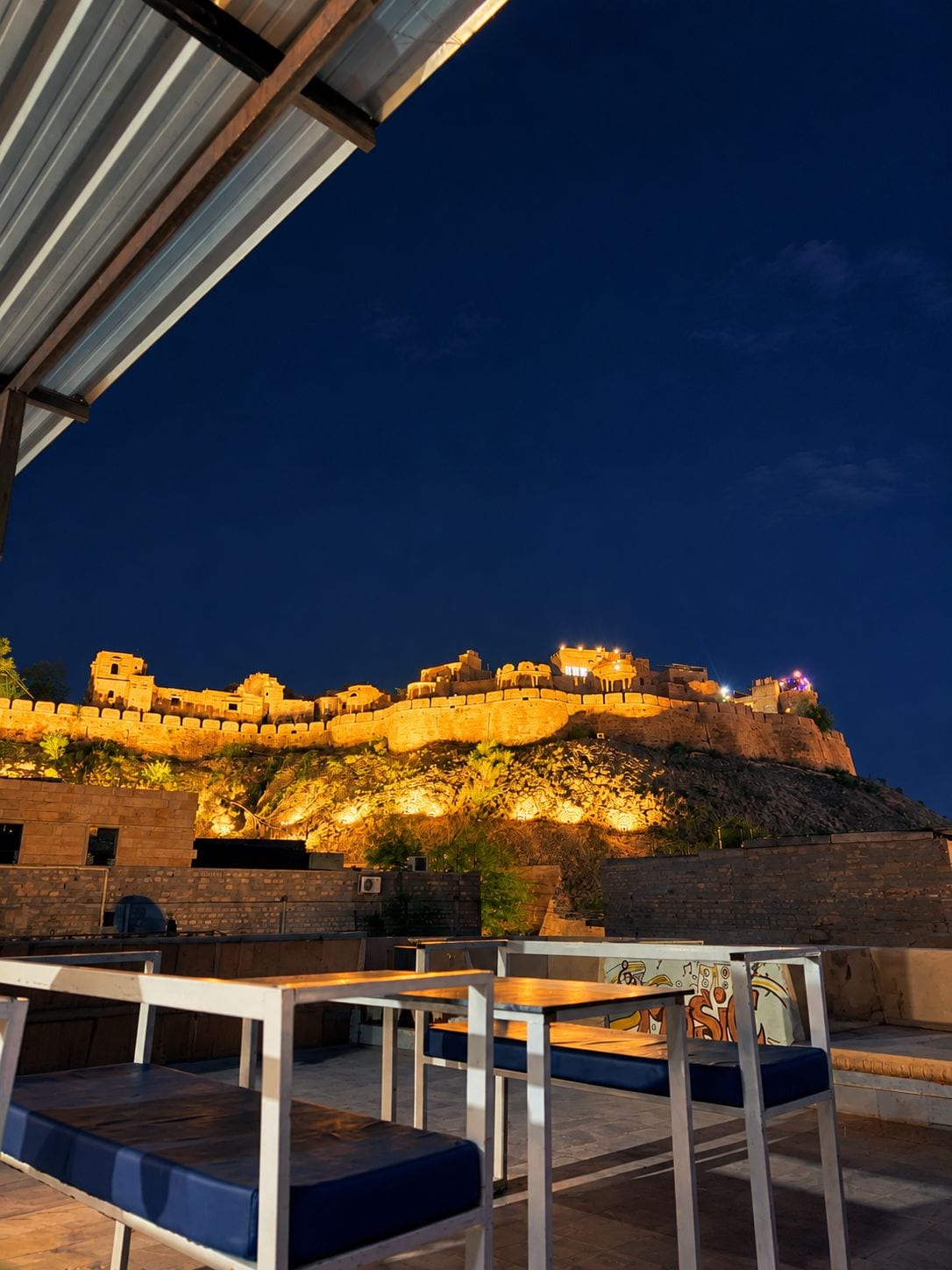 A view of a historic fort with a dining area in the foreground.
