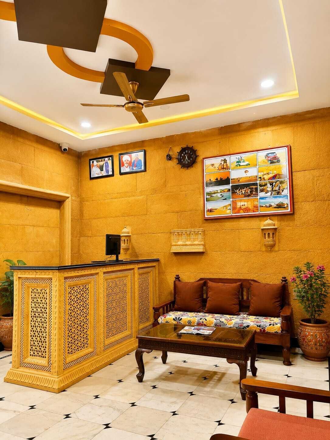 Um hall de entrada com uma recepção, um sofá, uma mesa de centro, um ventilador de teto e uma parede com quadros.