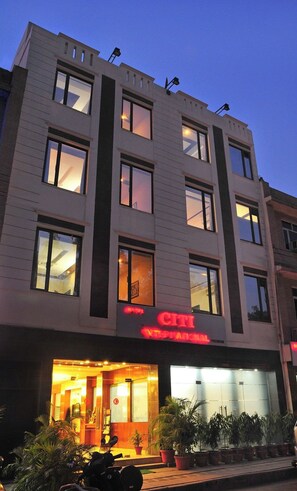 A multi-story hotel with a well-lit entrance, large windows, and a visible sign indicating it is a hotel. - HOTEL CITI INTERNATIONAL (New Delhi)