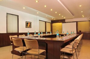 A conference room with a long table, chairs, water bottles, and a projector screen. - HOTEL CITI INTERNATIONAL (New Delhi)