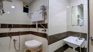 A bathroom with a toilet, shower, and sink. - Deluxe Room Santacruz Metro (Mumbai)