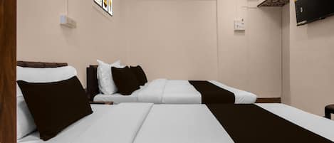 A hotel room with two beds, a flat-screen TV mounted on the wall, and a small table.