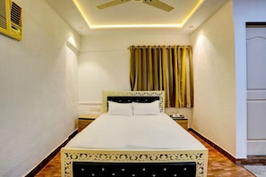 Ein Hotelzimmer mit Bett, Nachttisch und Deckenventilator.
