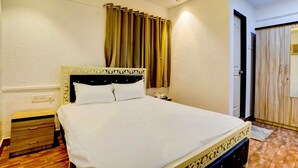 A hotel room with a bed, bedside table, and a wardrobe. - Deluxe Room Santacruz Metro (Mumbai)