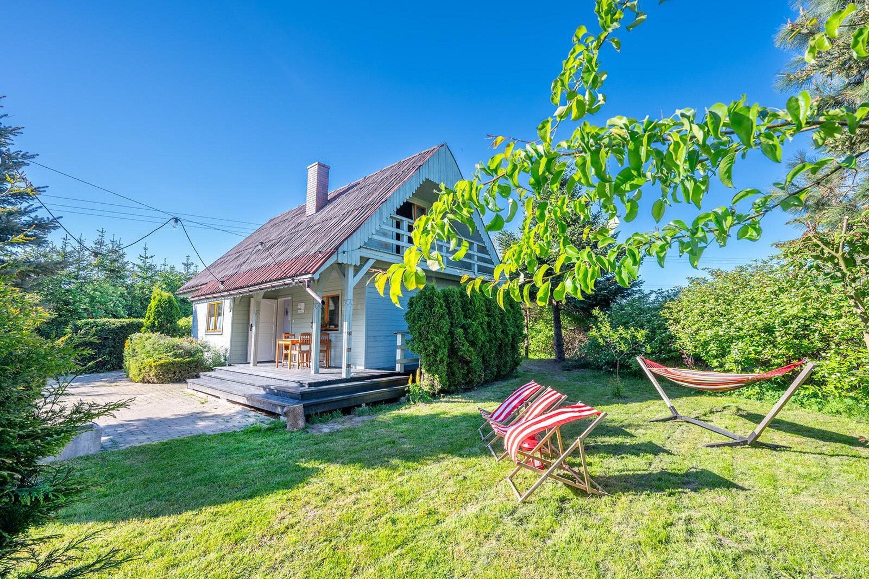 A house with a porch, a hammock, and a lawn.