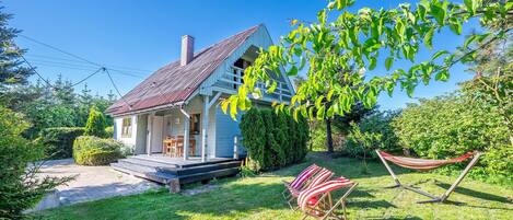 A house with a porch, a hammock, and a lawn.