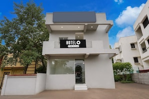 A modern hotel building with a sign reading 'HOTELO' and 'YOYO-Serviced'.
