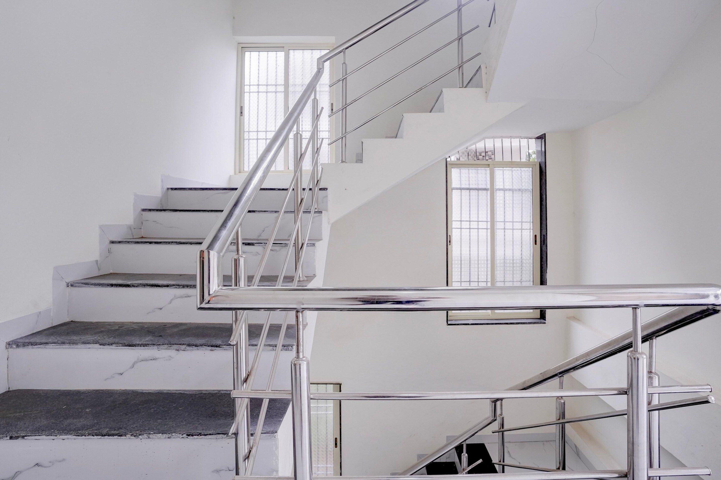 A staircase with a metal handrail and glass doors leading to another level.