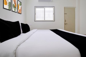 A bedroom with a bed, a window, and a door.