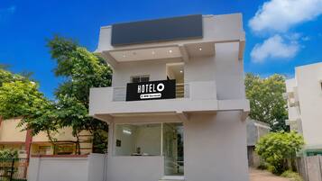 Un hotel moderno de dos pisos con un cartel que indica que cuenta con servicios de OYO.