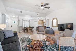 A modern living room with a sofa, a coffee table, and a television. - Peaceful 3-bedroom house with AC in charming Largo (Largo)
