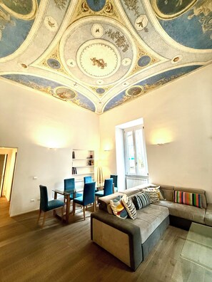 A room with a dining area, a sofa, and a ceiling with intricate designs. - Luxury Residence in Central Rome by Spanish Steps (Roma)
