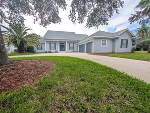 A two-story residential house with a driveway, front yard, and a palm tree. - Monterey Bay Retreat | Private Pool + Gated (Jacksonville)