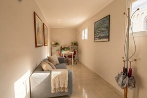 A living room with a sofa, a dining area with a table and chairs, and a painting on the wall. - 3-Bedroom Luxury Residence with 4 Beds & 2 Bathrooms in Bari (Bari)