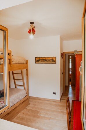 A room with a bunk bed, a wooden ladder, a wall-mounted light fixture, and a framed picture. - Dimora del Cervo | Luxury Dolomites Retreat. Spectacular mountain view (Falcade)