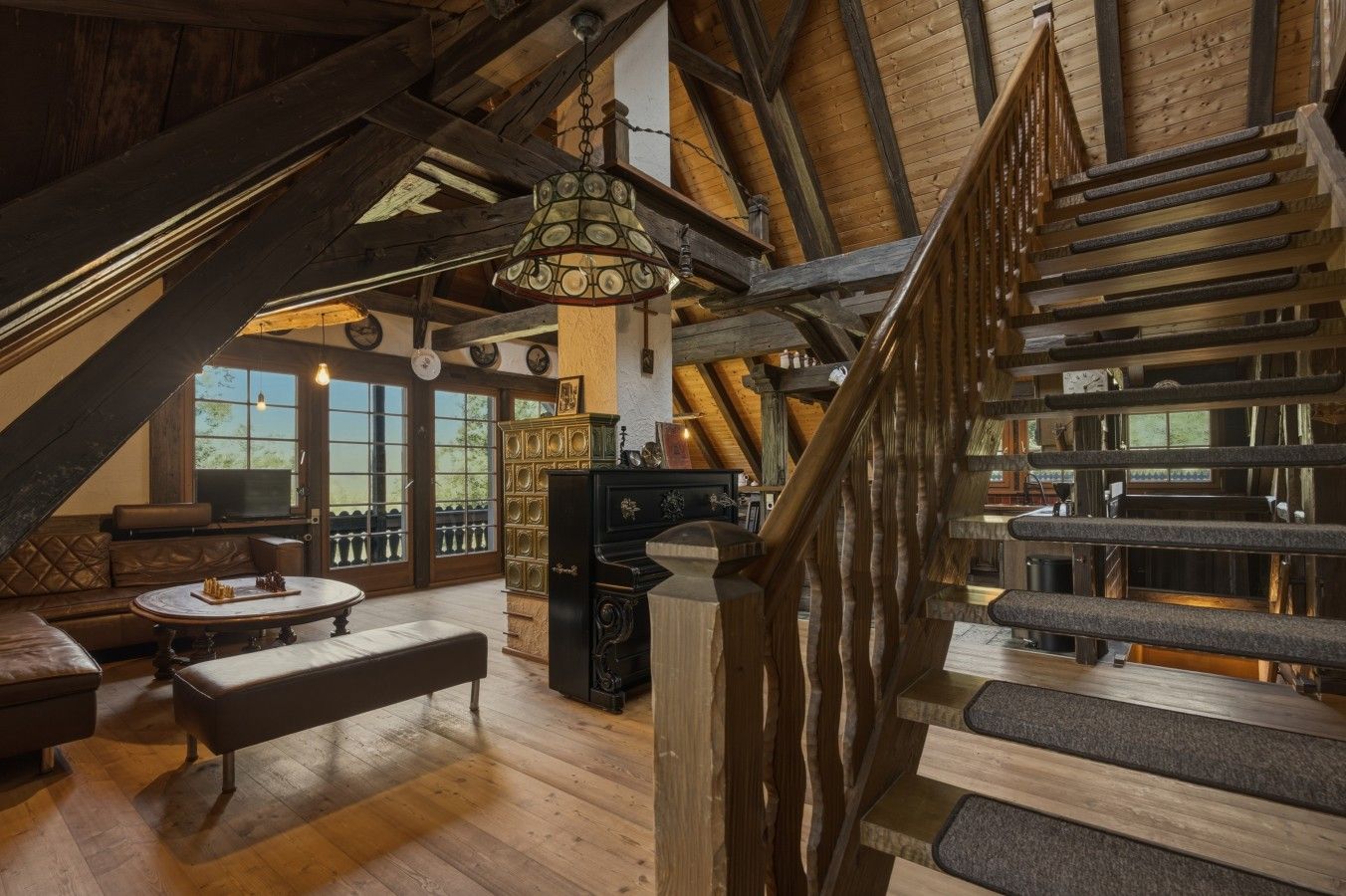 Un intérieur rustique avec un escalier en bois, un coin repas et un espace salon confortable.