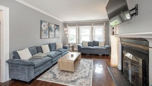 A living room with two sofas, a coffee table, and a fireplace. - Spacious house in University heights (University Heights)