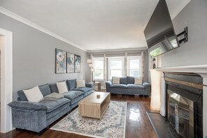 Ein Wohnzimmer mit zwei Sofas, einem Couchtisch und einem Kamin.