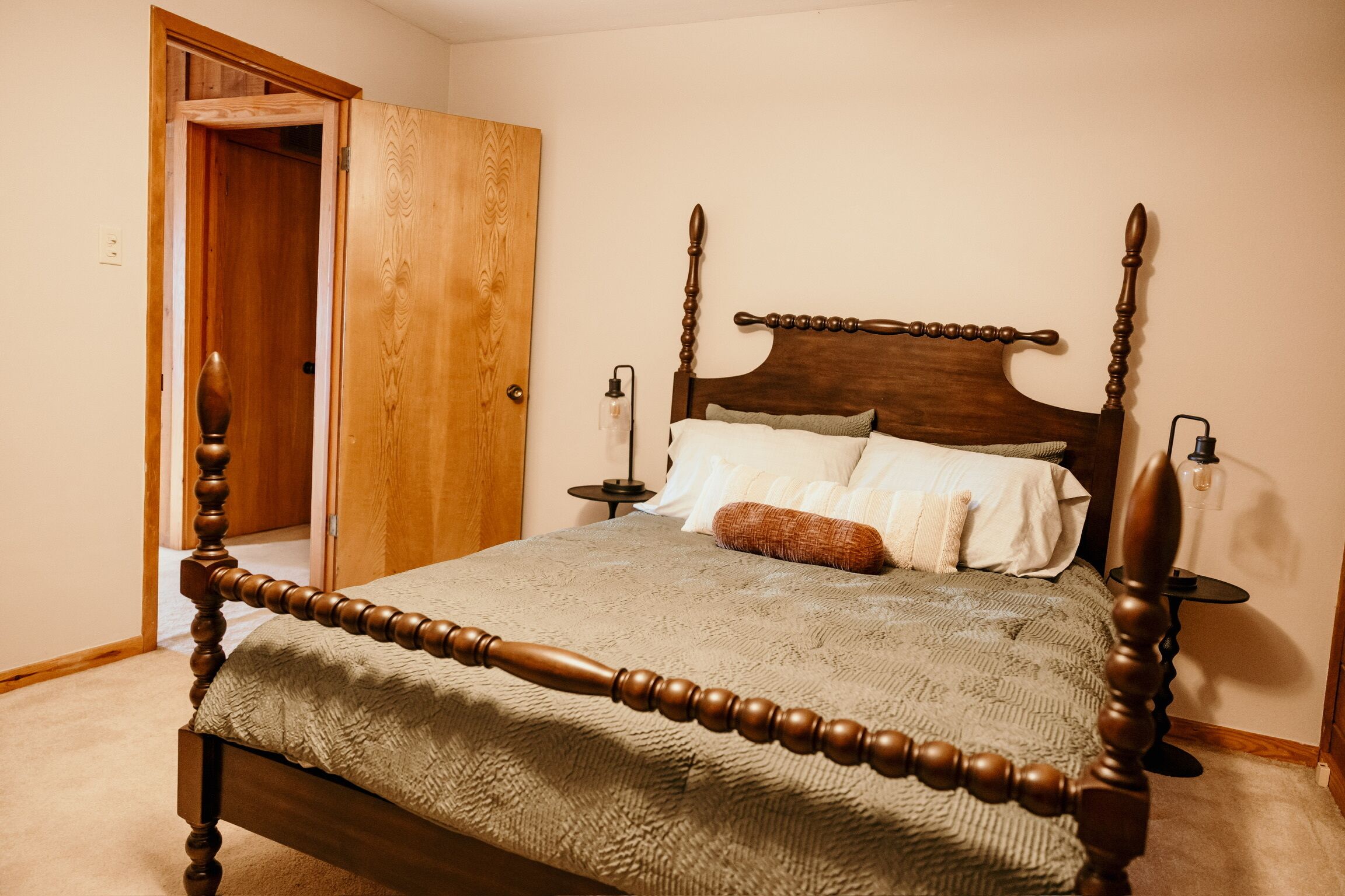 Un lit à baldaquin avec un cadre en bois et une couvre-lit à motifs.
