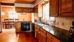 A kitchen with wooden cabinets, a stainless steel countertop, and a built-in oven. - Charming 3-bedroom cabin with AC on Lone Star Lake (Lone Star)