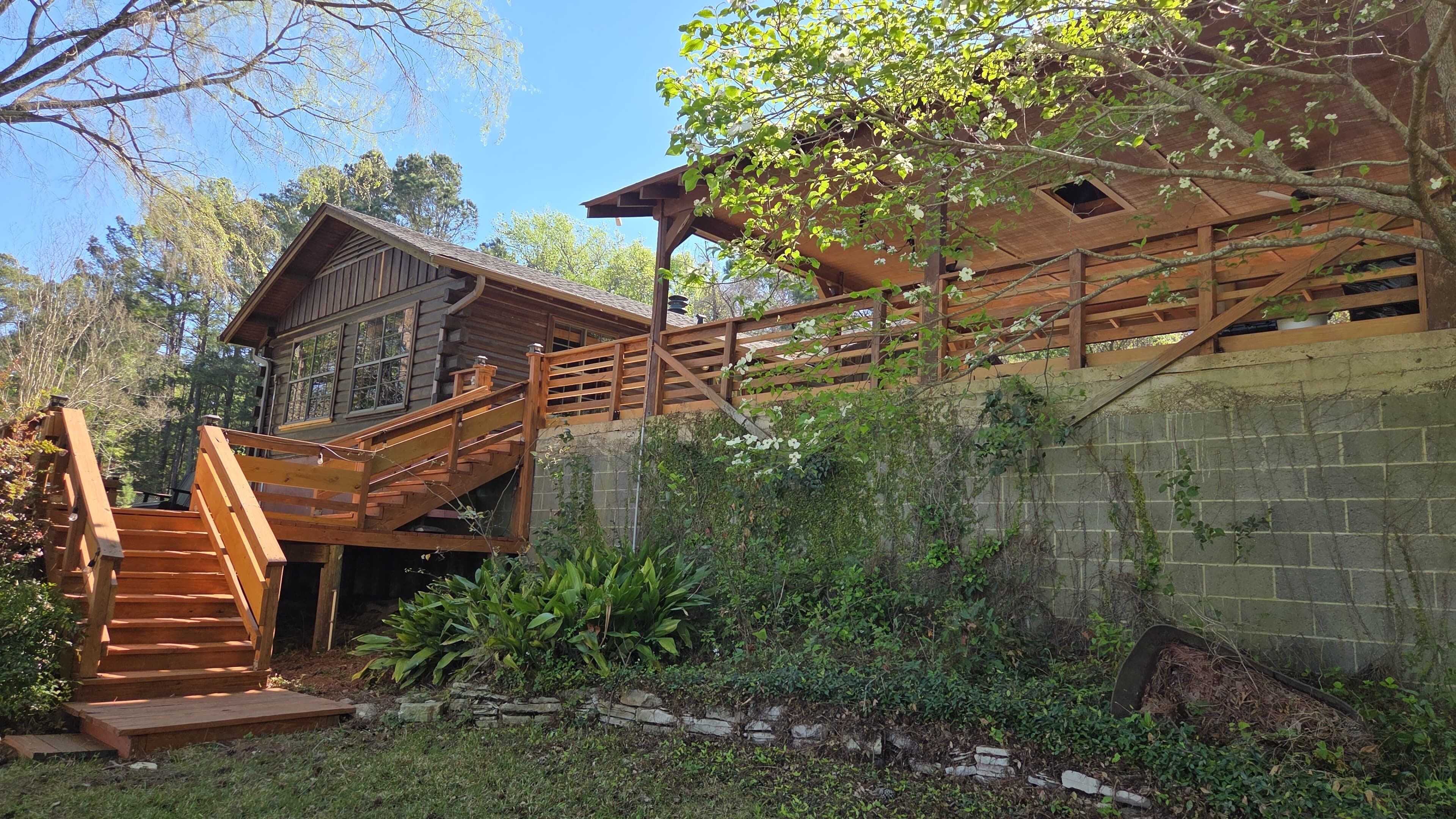 A wooden cabin with a staircase leading to a deck.