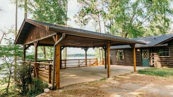 A wooden cabin with a covered porch overlooking a lake.