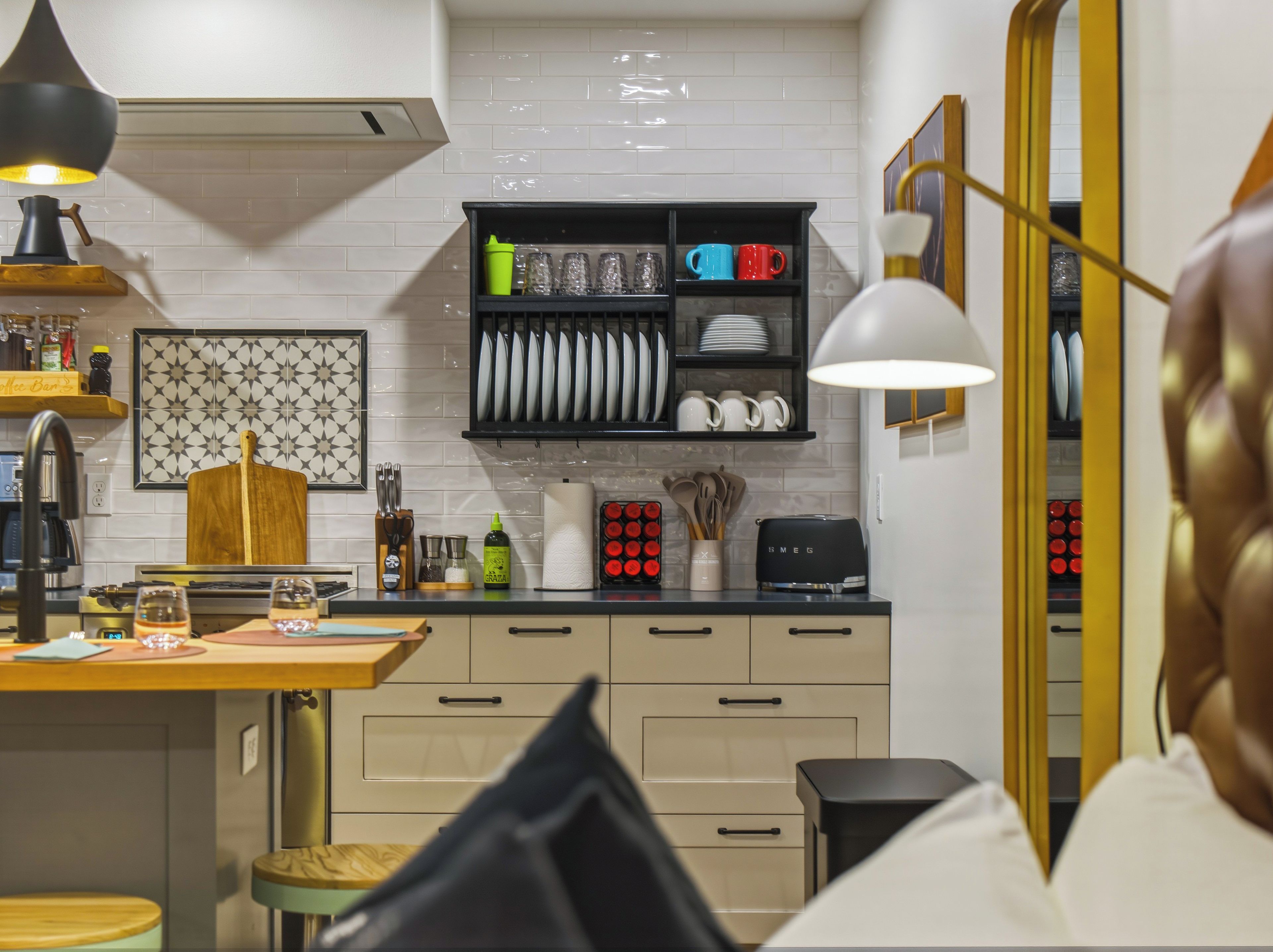 A modern kitchen with a black countertop, a wooden cutting board, and a variety of kitchenware.