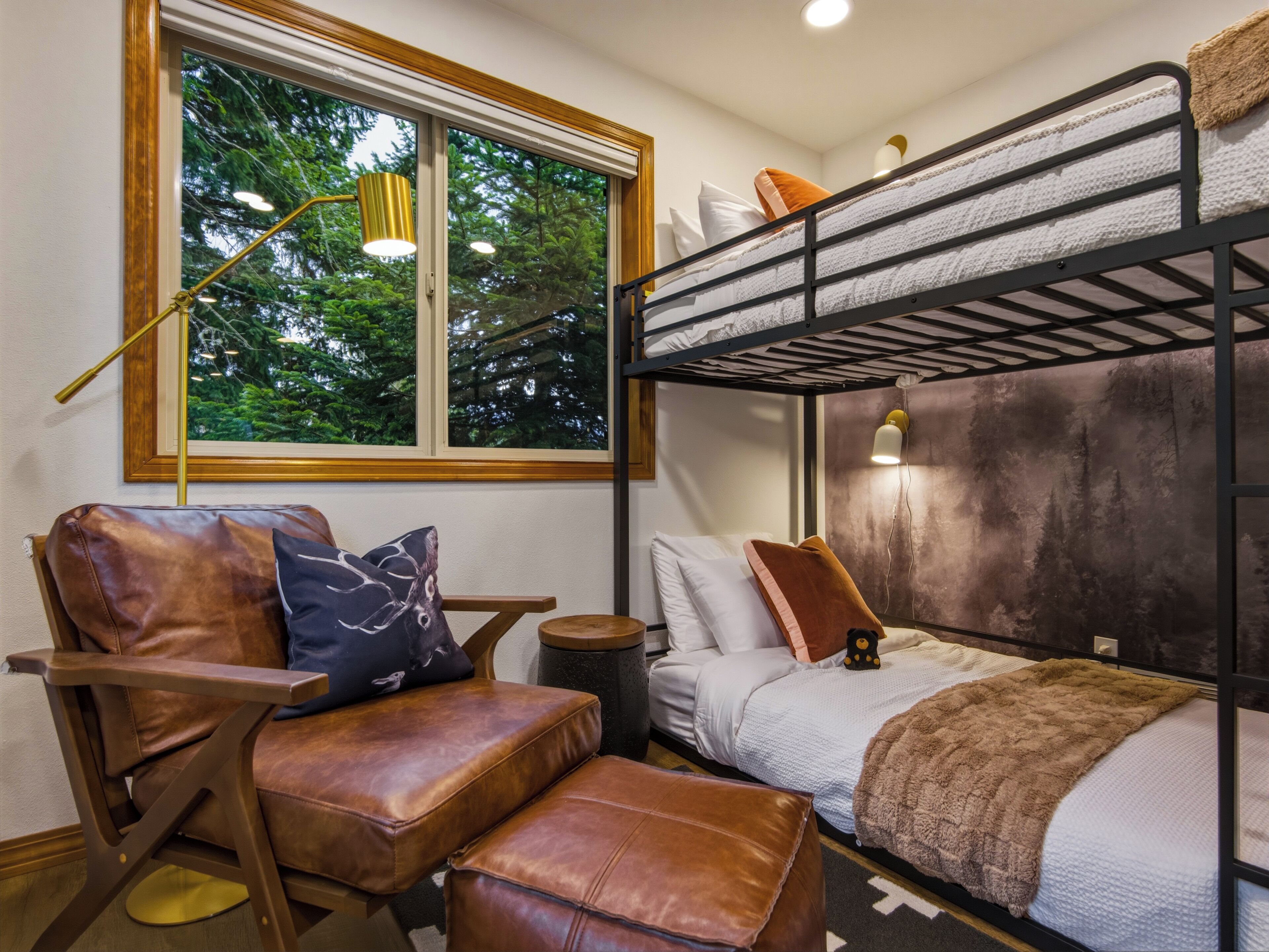 Une chambre avec un lit superposé, une fenêtre, un bureau et une chaise.