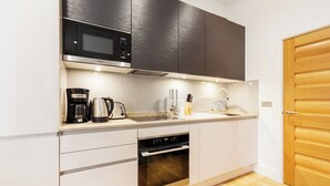 Cocina compacta con microondas, cafetera, tostadora, pileta y horno.