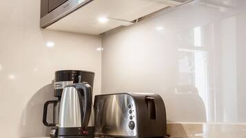 A modern kitchen with a built-in microwave, a coffee maker, and a toaster.