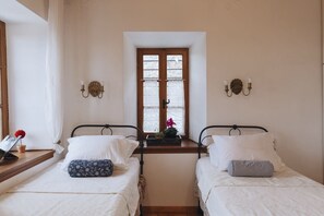 A room with two beds, a window with a view, and wall-mounted lamps. - Stone Villa in Koukourava Pelion with Private Pool and Panoramic Sea Views (koukourava)