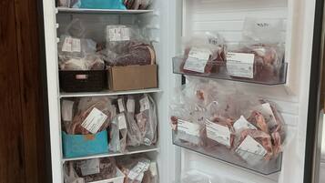 Geladeira com várias prateleiras contendo diversos alimentos embalados.
