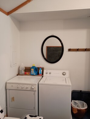 A laundry room with two washing machines, a drying rack, and a mirror on the wall. - Weber Hill Farm Cabin in Bovina! Operating Dairy Farm visits available with stay (Bovina Center)