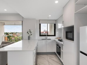 Comfort Apartment, Balcony | Private kitchen | Oven, stovetop, cookware/dishes/utensils - Timi Property (Woolloongabba)