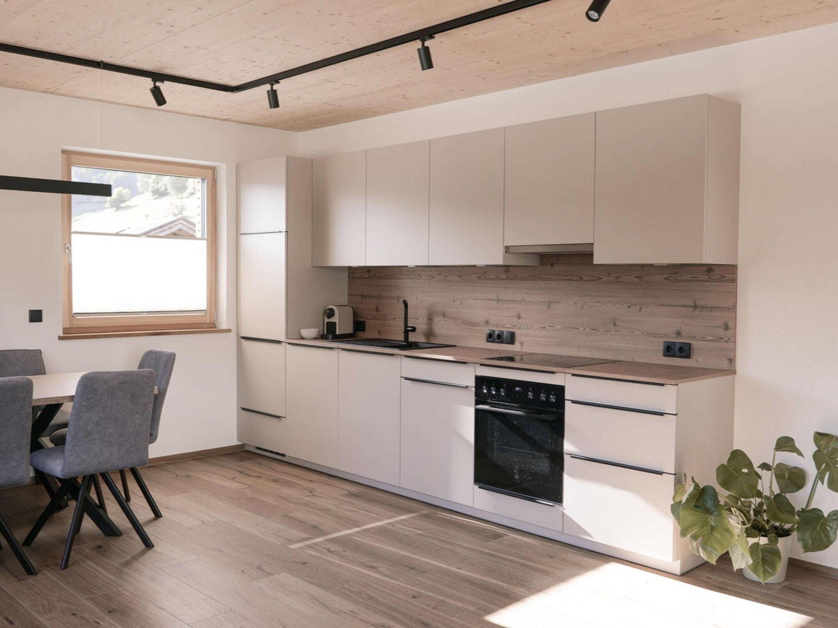 Una cucina moderna con mobili bianchi, un piano di lavoro in legno e una lavastoviglie integrata.