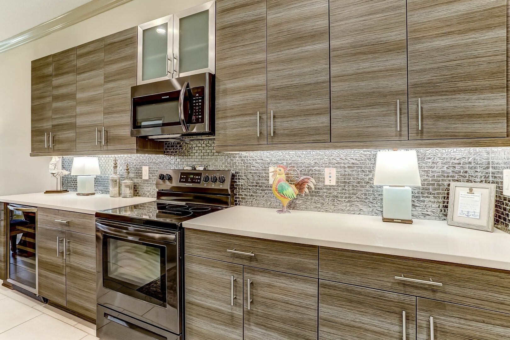 A modern kitchen with a central island, stainless steel appliances, and a decorative rooster.